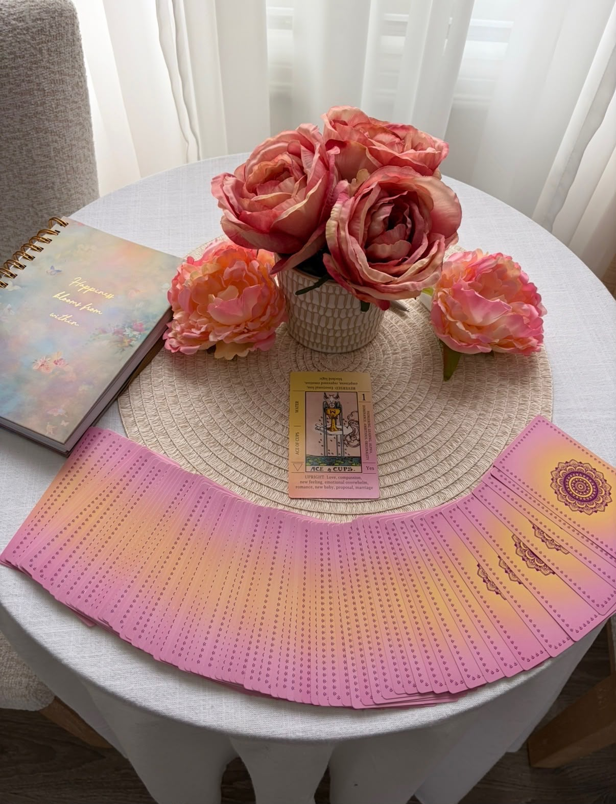 Kate Lovemore's shadow work tools with tarot cards fanned across a table, pink roses, and a journal